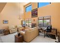 Bright living room featuring soaring ceilings, ample natural light, and a cozy seating area at 14186 N 100Th Pl, Scottsdale, AZ 85260