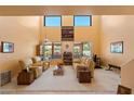 Spacious living room with high ceilings, large windows, and comfortable seating arrangement at 14186 N 100Th Pl, Scottsdale, AZ 85260