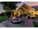 Inviting home exterior at twilight, featuring a stone facade, fountain, and manicured landscaping at 2558 E Page Ct, Gilbert, AZ 85234