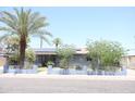 Charming single-story home featuring desert landscaping, a palm tree, and solar panels at 2718 W Montebello Ave, Phoenix, AZ 85017