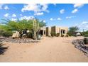 Gorgeous single-story home showcasing desert landscaping and mature trees under a partly cloudy sky at 27203 N 64Th Way, Scottsdale, AZ 85266