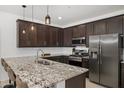 Well-appointed kitchen featuring stainless steel appliances, a large granite island with seating, and ample cabinet space at 29431 N 122Nd Gln, Peoria, AZ 85383