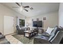 Inviting living room with comfortable seating, a ceiling fan, and a view of the outside through a window at 3534 N 106Th Ln, Avondale, AZ 85392