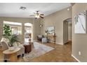 Inviting living room featuring tile floors, neutral walls, ceiling fan and view into the kitchen at 4101 S Dewdrop Ct, Gilbert, AZ 85297