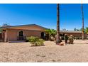 Single-story brick home with desert landscaping, arched windows, and tall palm trees under a clear sky at 533 E 7Th Pl, Mesa, AZ 85203