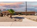 Charming single-story home featuring desert landscaping, a walkway, and a classic brick facade under a colorful sky at 533 E 7Th Pl, Mesa, AZ 85203