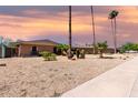 Single-story brick home with desert landscaping, arched windows, and tall palm trees with a colorful sky at 533 E 7Th Pl, Mesa, AZ 85203