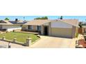 Well-maintained single-story home with a manicured lawn, brick accents, and a two-car garage at 5349 W Acapulco Ln, Glendale, AZ 85306