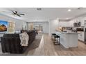 Bright and open-concept living area with tiled floors, a kitchen island, and a comfortable seating arrangement at 654 E Buckingham Ave, Gilbert, AZ 85297