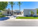 Beautiful home featuring desert landscaping, palm trees, and a circular driveway at 7878 E Gainey Ranch Rd # 36, Scottsdale, AZ 85258