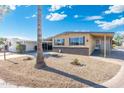Inviting single-story home with gravel landscaping, a covered carport, and mature palm trees at 11411 N 91St Ave Ave # 87, Peoria, AZ 85345