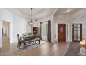 Formal dining room with a stylish chandelier, wood floors, and a large window for natural light at 1213 W Beck Ln, Phoenix, AZ 85023