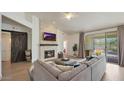 Bright living room featuring a cozy fireplace, modern furniture, and sliding glass doors leading to the patio at 1213 W Beck Ln, Phoenix, AZ 85023