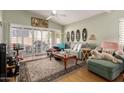 Comfortable living room with a large sofa, ceiling fan, and sliding doors leading to the backyard at 14428 W Moccasin Trl, Surprise, AZ 85374