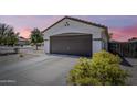 Home's inviting exterior showcasing a two-car garage and easy-care landscaping at 16523 W Desert Bloom St, Goodyear, AZ 85338