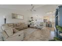 Bright, open-concept living room featuring tile floors, neutral decor, and a ceiling fan at 16523 W Desert Bloom St, Goodyear, AZ 85338