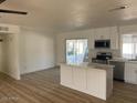 Bright kitchen with island, stainless appliances, and sliding glass door leading to the backyard at 18045 N 20Th N Ln, Phoenix, AZ 85023