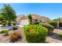 Charming single-story home featuring a well-manicured front yard with mature landscaping at 2053 E Saddlebrook Ct, Gilbert, AZ 85298