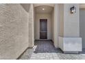 Inviting front entryway with a dark wood door, textured walls, and elegant paver pathway at 22788 E Orion Way, Queen Creek, AZ 85142