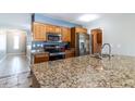Spacious kitchen featuring granite countertops, stainless steel appliances, and oak cabinetry at 2338 E Javelina Ave, Mesa, AZ 85204