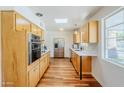 Well-lit kitchen with wood cabinets, stainless steel appliances, and a skylight at 314 E Royal Palm Rd, Phoenix, AZ 85020