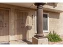 Close-up of front entry showcasing secure door, exterior lighting, and decorative pillar at 4601 N 102Nd Ave # 1178, Phoenix, AZ 85037