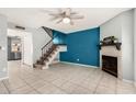 Inviting living room features a tile floor, staircase, and fireplace with decorative mantel at 4601 N 102Nd Ave # 1178, Phoenix, AZ 85037