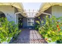 Inviting covered entryway with decorative plants and a lattice overhang, leading to the front door at 5751 W Muriel Dr, Glendale, AZ 85308