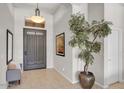 Bright entryway featuring neutral tile flooring, a decorative tree, and a paneled front door at 6135 E Campo Bello Dr, Scottsdale, AZ 85254