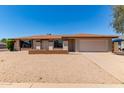 Inviting single-story home featuring a desert-style landscaped front yard with a two-car garage at 662 W Laguna Azul Ave, Mesa, AZ 85210