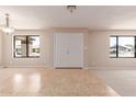Bright living room featuring neutral walls, tiled floors, modern lighting, and large windows at 662 W Laguna Azul Ave, Mesa, AZ 85210