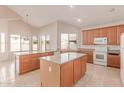 Bright kitchen with wooden cabinets, center island, and modern appliances, complemented by tile flooring at 7418 S 25Th Ln, Phoenix, AZ 85041