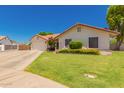 Inviting one-story home with a lush front lawn and a convenient two-car garage at 930 N Sandal Cir, Mesa, AZ 85205