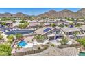 Bird's eye view of a desert home with a pool, green landscaping, and beautiful mountain views at 9347 E Hillview Cir, Mesa, AZ 85207