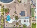 Aerial view of a backyard showcasing a beautiful pool, hot tub, landscaping, and rooftop solar panels at 9347 E Hillview Cir, Mesa, AZ 85207