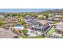 Expansive backyard with a sparkling pool, hot tub, and lush desert landscaping in a mountain view community at 9347 E Hillview Cir, Mesa, AZ 85207