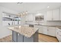 Bright, remodeled kitchen featuring white cabinetry, granite countertops, and modern pendant lighting above the kitchen island at 1017 S Allen --, Mesa, AZ 85204