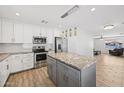 Modern kitchen features granite counters, stainless appliances, ample cabinet space, and an island with stylish pendant lighting at 1017 S Allen --, Mesa, AZ 85204