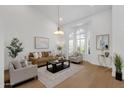 Bright living room featuring large windows, wood floors, and neutral furnishings under a decorative chandelier at 12638 E Cortez Dr, Scottsdale, AZ 85259