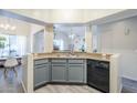 Contemporary kitchen with stainless steel sink and black dishwasher; large windows with natural light at 1331 W Baseline Rd # 360, Mesa, AZ 85202