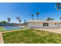 This backyard boasts lush grass, gravel landscaping, and a sport court for active outdoor living at 13805 N 31St Ave, Phoenix, AZ 85053