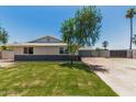 Charming single-story home with a well-manicured lawn, inviting curb appeal, and a long driveway at 13805 N 31St Ave, Phoenix, AZ 85053
