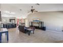 Open-concept living space with tile flooring, ceiling fan, and access to the kitchen and dining area at 14822 N Tonya Cir, El Mirage, AZ 85335