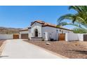 Single-story house with white exterior, tile roof, palm trees, and a long driveway at 1809 E Gwen St, Phoenix, AZ 85042