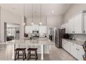 Bright kitchen featuring a spacious island, stainless steel appliances, and white cabinetry at 18459 E Ranch Rd, Queen Creek, AZ 85142