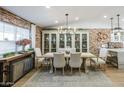 Inviting dining room with a long wood table, seating for eight, brick wall accent, and soft, natural light at 2111 W Mulberry Dr, Phoenix, AZ 85015