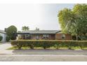 Charming brick home with a well-maintained front yard and mature trees and a covered front porch at 2111 W Mulberry Dr, Phoenix, AZ 85015