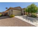 View of a home with a two-car garage, desert landscaping, and a satellite dish, set against a clear blue sky at 25945 W Runion Dr, Buckeye, AZ 85396