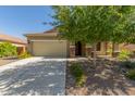 Attractive home featuring a two-car garage, desert landscaping, and a well-maintained lawn, enhancing its curb appeal at 25945 W Runion Dr, Buckeye, AZ 85396