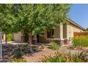 Charming home exterior with stone accents, a well-manicured lawn, and a variety of colorful flowers enhancing its curb appeal at 25945 W Runion Dr, Buckeye, AZ 85396